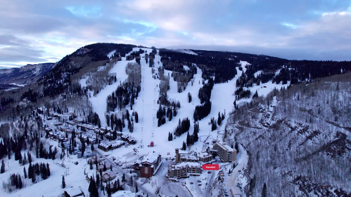 A panoramic exterior view highlights snow-dusted ski slopes, mountain resorts, majestic peaks, and snow-covered trees. The image exudes an adventurous yet cozy winter atmosphere, inviting exploration and après-ski relaxation.